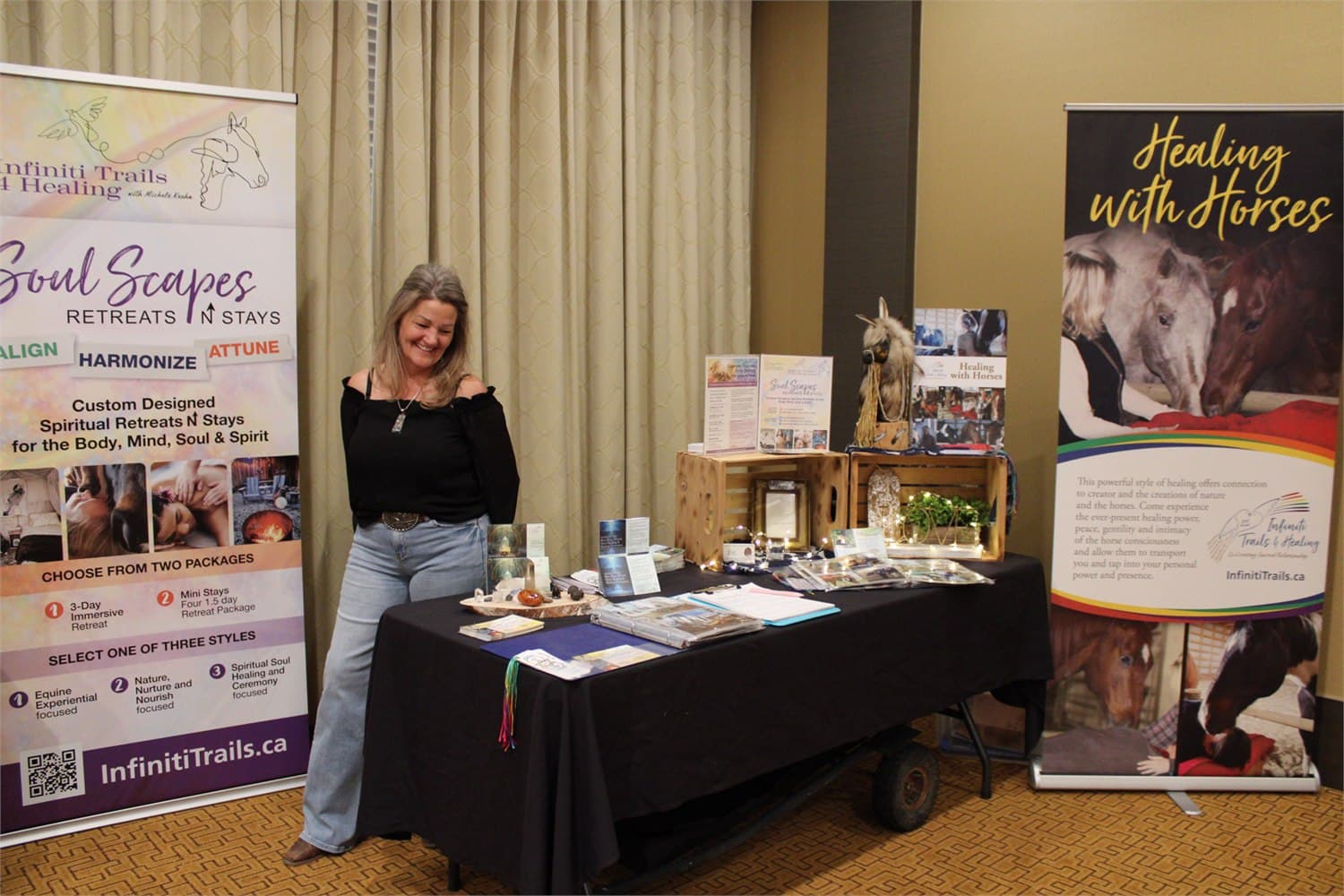 A local maker at her table in the room before doors, banners either side and her work laid out.